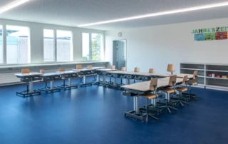 Schulzimmer mit Pulten in Schulhaus mit teporärer Erweiterung durch Aufstockung in Holzmodul-Bauweise
