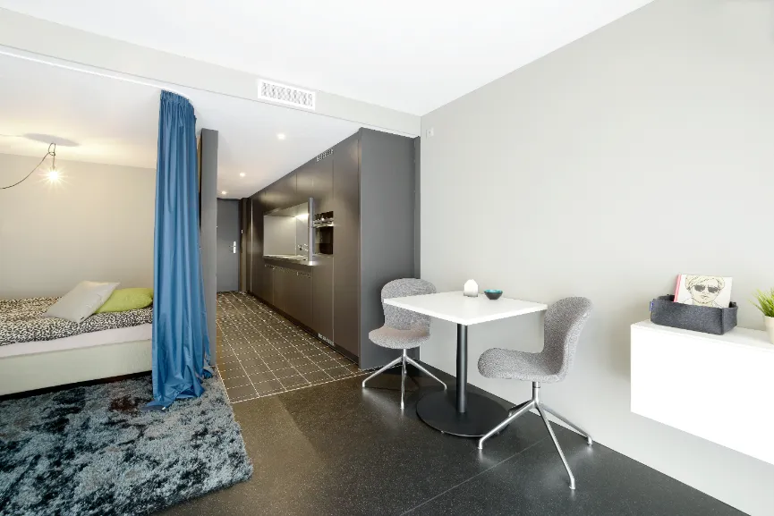 Wohnraum und Schlafzimmer sowie Küchenzeile eines UNUS-Apartments in Kreuzlingen in Minergie-P